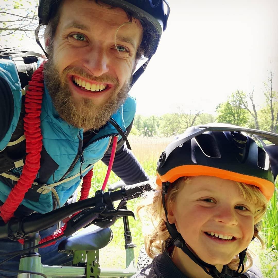 Dad and son smiling together,dad has a tow whee cord over his shoulder, taken by instagram @kristianskjodt